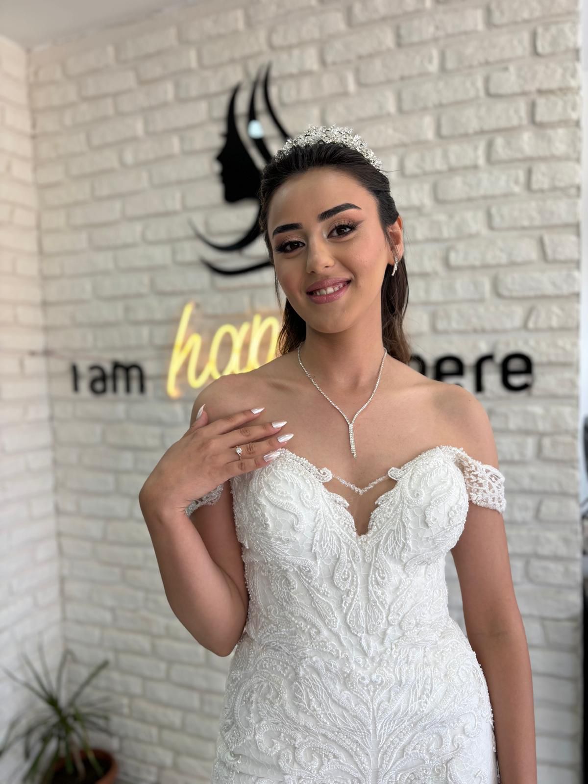 Dantel gelinlikli gelin, taç ve toplu saç ile